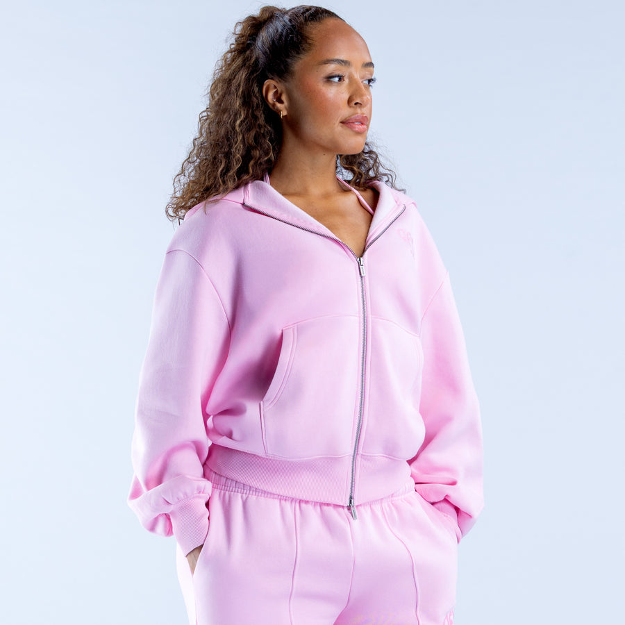 Pink zip-up hoodie with hood, kangaroo pocket, and ruffled hem