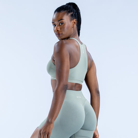 Sage green racerback sports bra, side view with open back straps