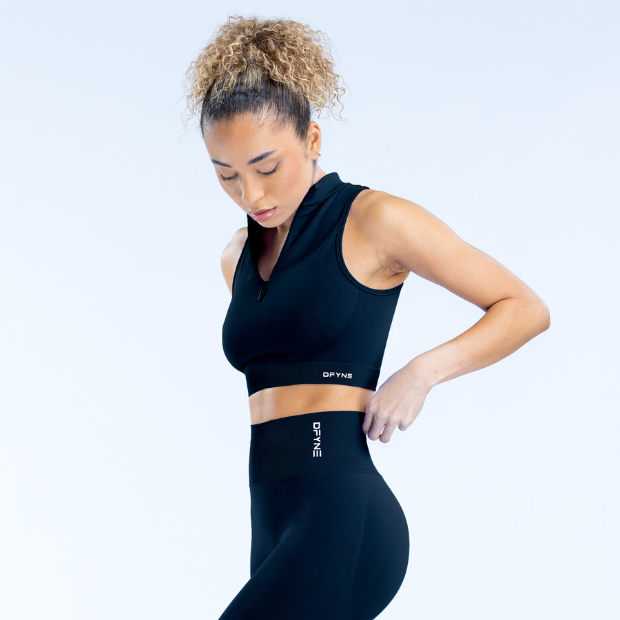 Black dynamic quarter-zip tank top with fitted waist seam and small logo label