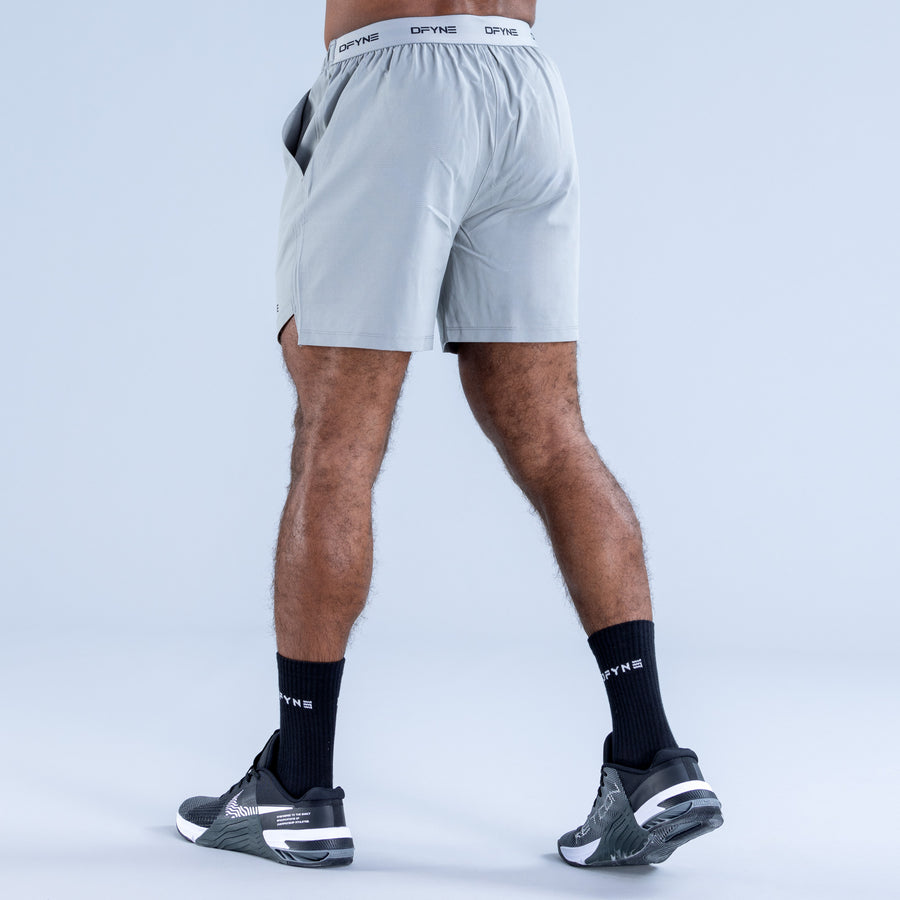 Light blue training shorts with elastic waistband and DPYNE logo, rear view