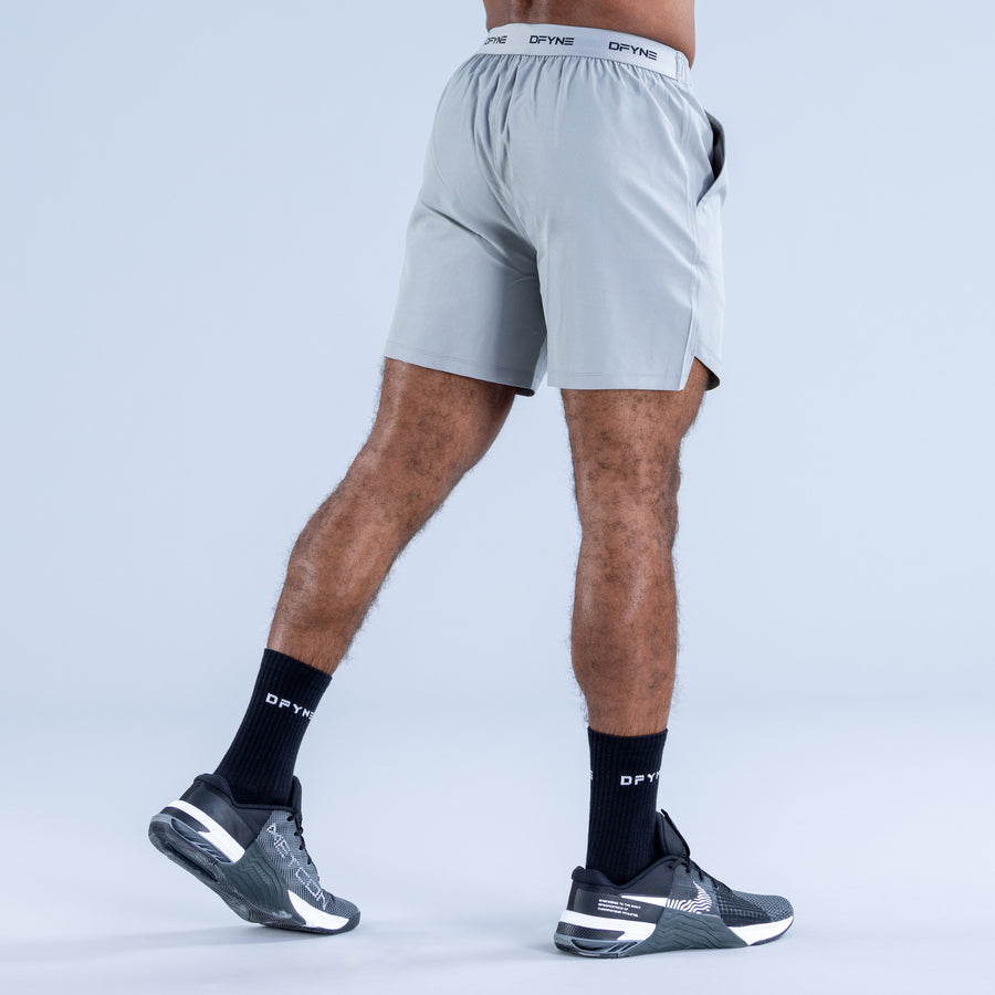 Light blue training shorts with elastic waistband and DPYNE logo, back view