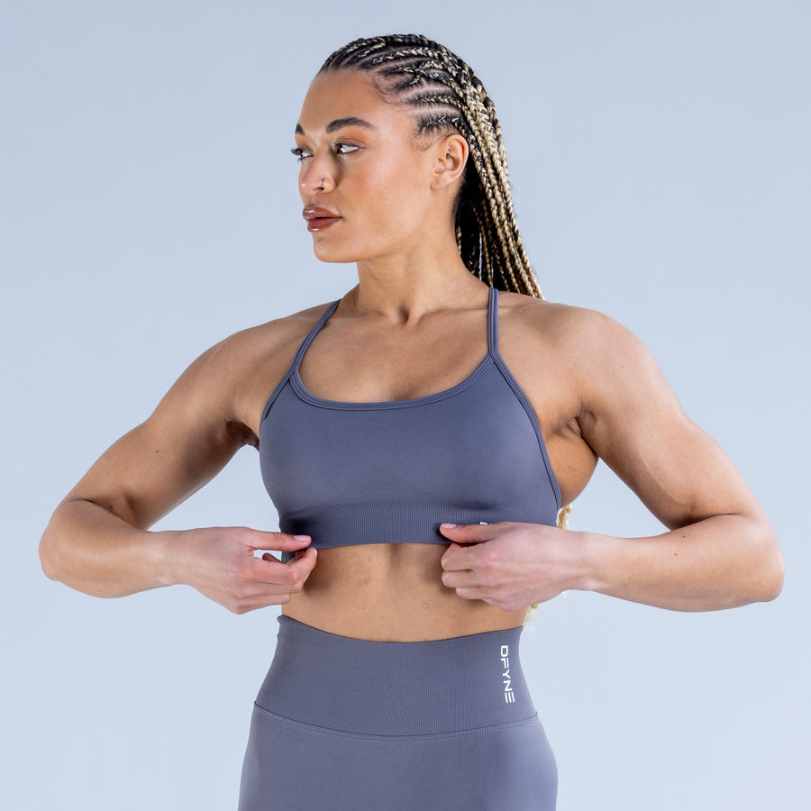 Backless sports bra in muted blue with scoop neckline and supportive stretch fit
