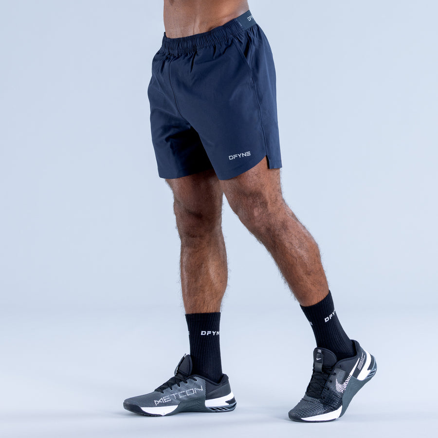 Navy training shorts with elastic waistband and side logo, above-knee length