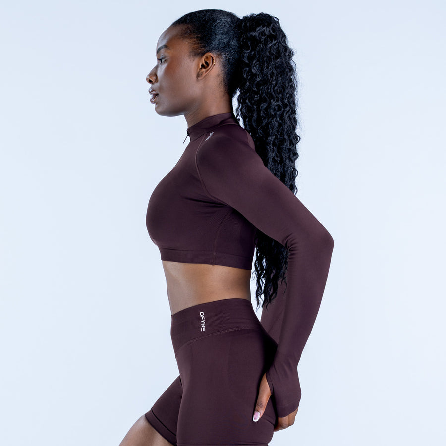 Dark plum cropped zip athletic top with long sleeves and matching biker shorts