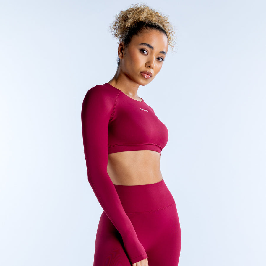 Magenta long-sleeve crop top with crew neck and fitted seams