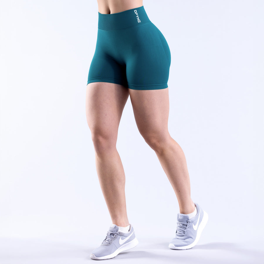 Teal compression-style women's shorts, mid-thigh length with elastic waistband