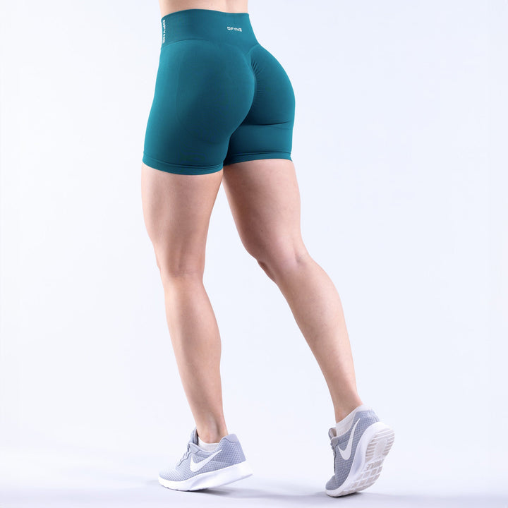 Women's teal 4.5-in athletic shorts, back view with contoured seams