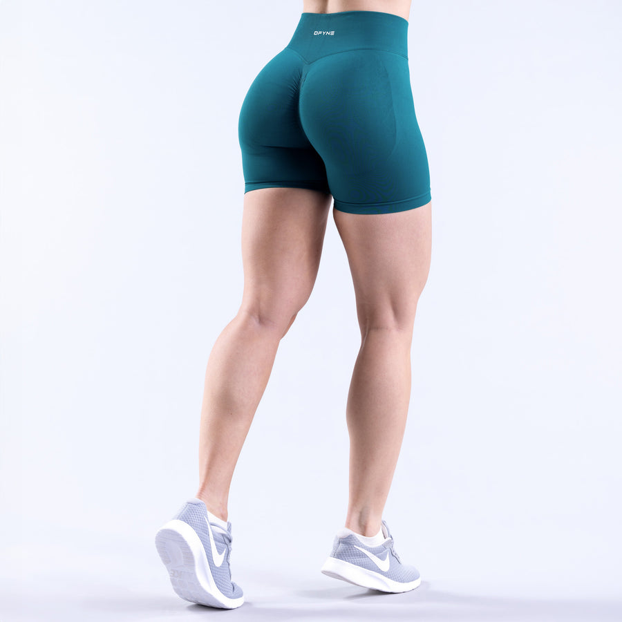 Teal women's athletic shorts with back yoke detail and mid-thigh cut