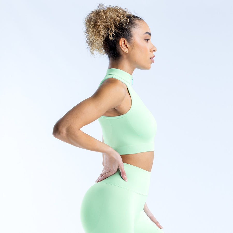 Mint green quarter-zip tank top, side view with fitted waist and high neck