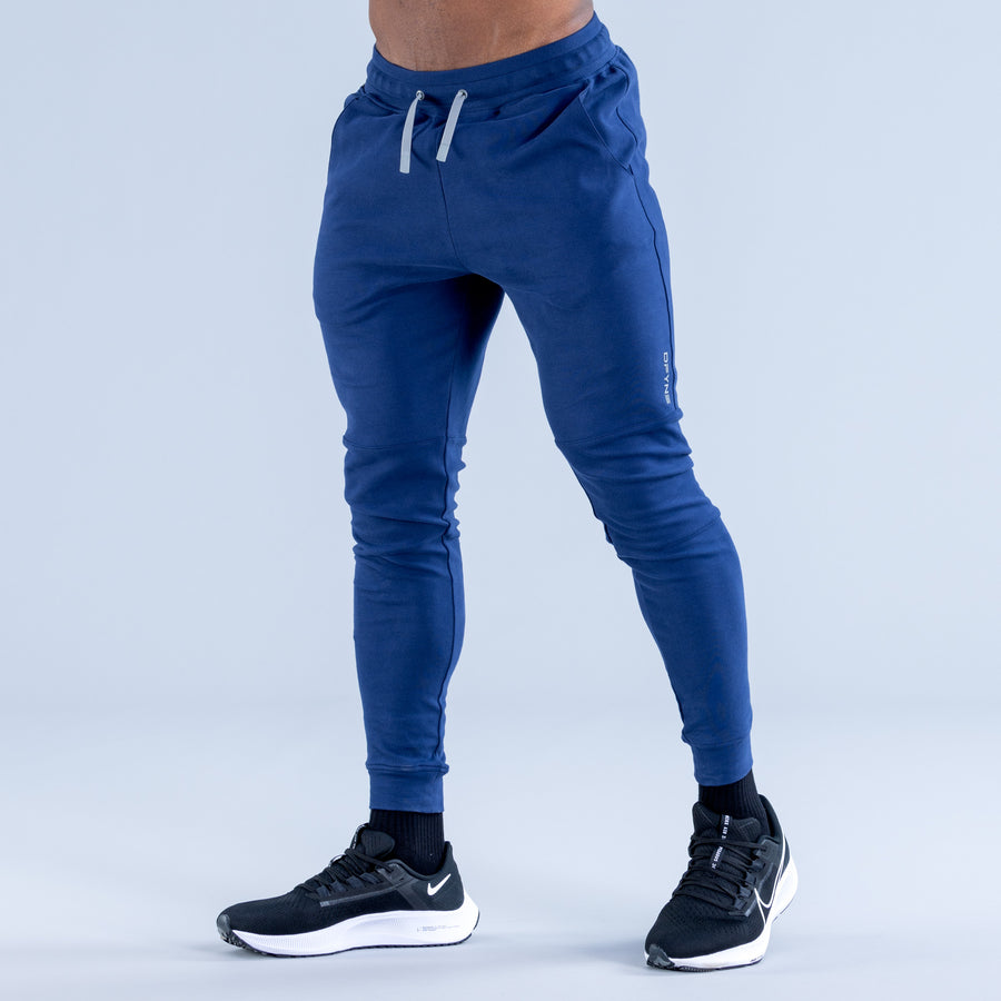 Blue tapered jogger pants with front pockets, drawstring and cuffed ankles