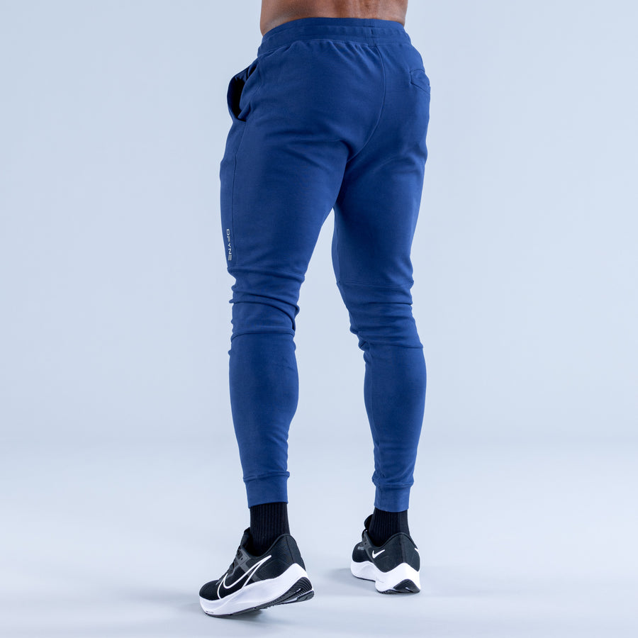 Blue tapered jogger pants, back view with drawstring waistband and cuffed ankles