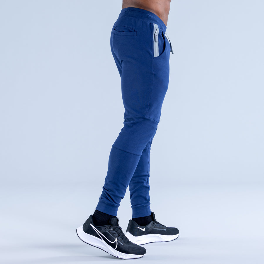Blue tapered jogger pants, side view with drawstring waistband and cuffed ankle