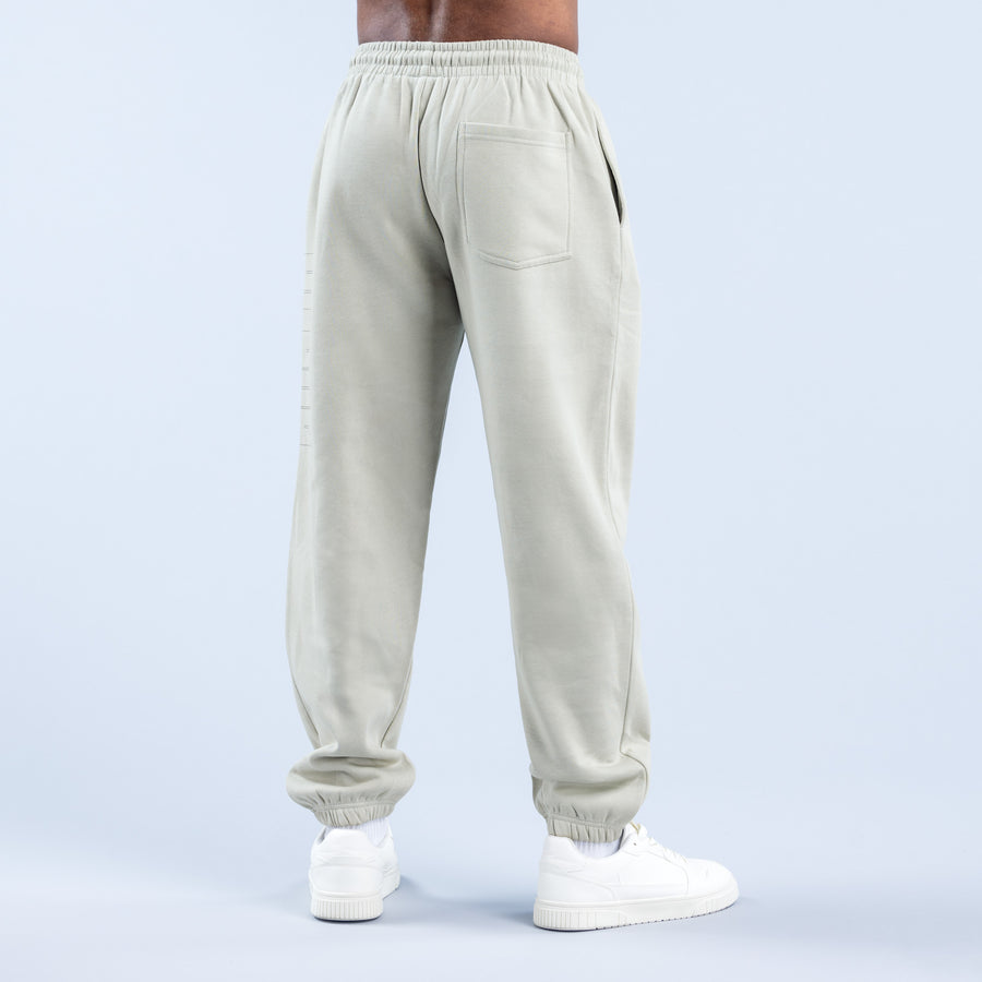Cream graphic jogger pants from back view with elastic waistband and tapered legs