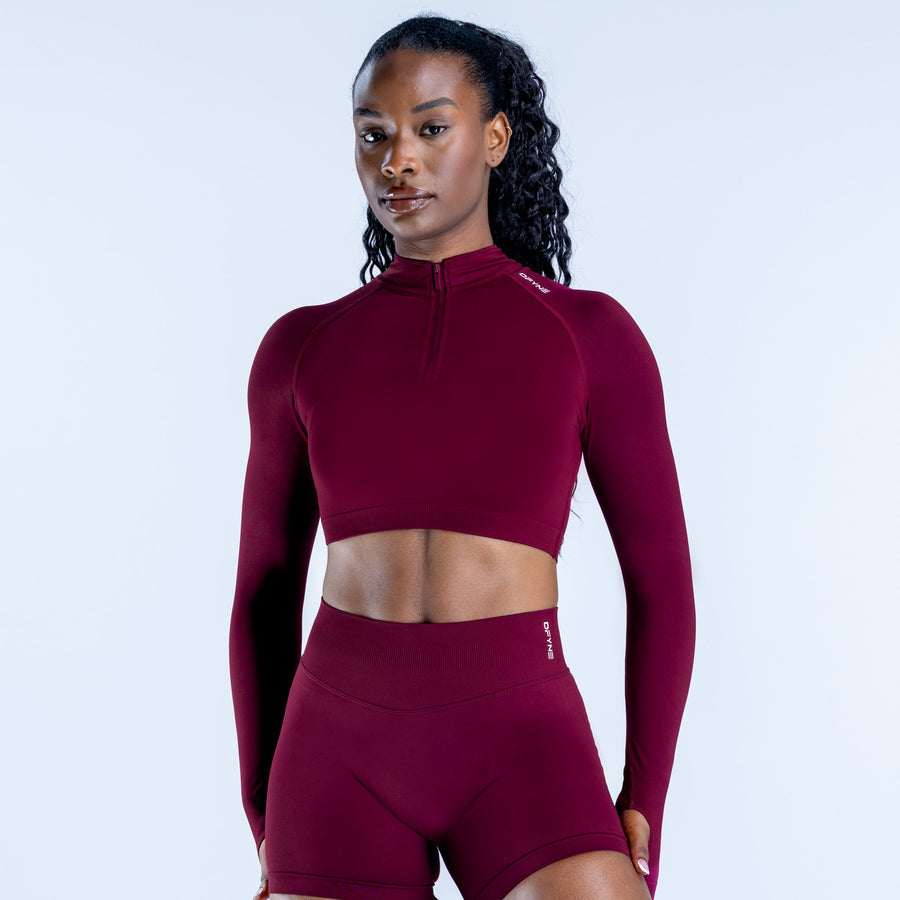 Burgundy long-sleeve quarter-zip crop top with high-waist cycling shorts