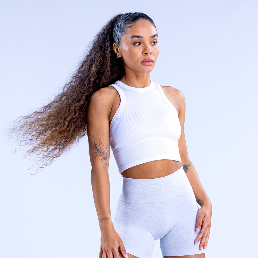 White racerback crop top with sleeveless front and fitted cropped hem