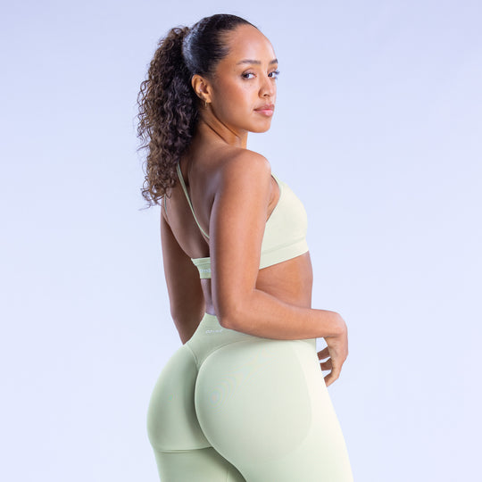 Asymmetric sports bra in light mint with racerback straps and wide back coverage