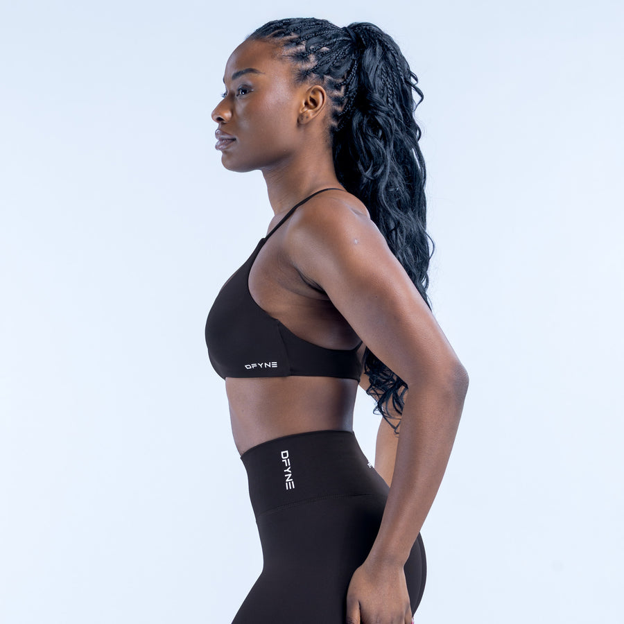 Black twist-back sports bra with thin straps, racer-back view