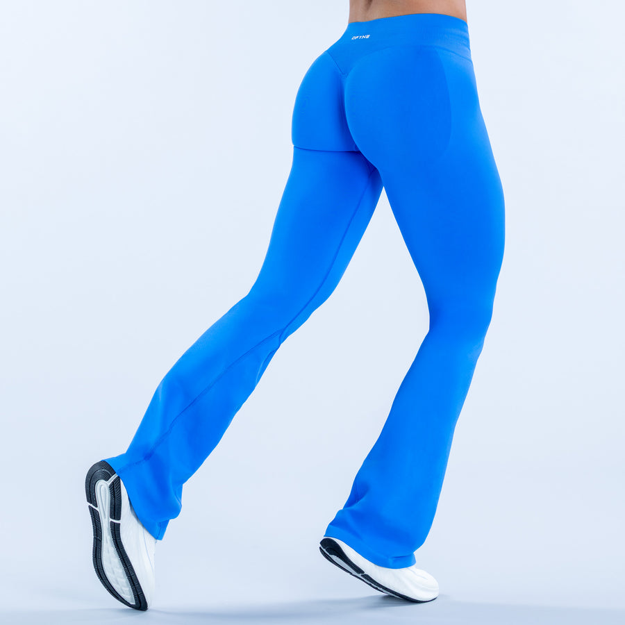 Bright blue high-rise flare leggings with flared hem, side view