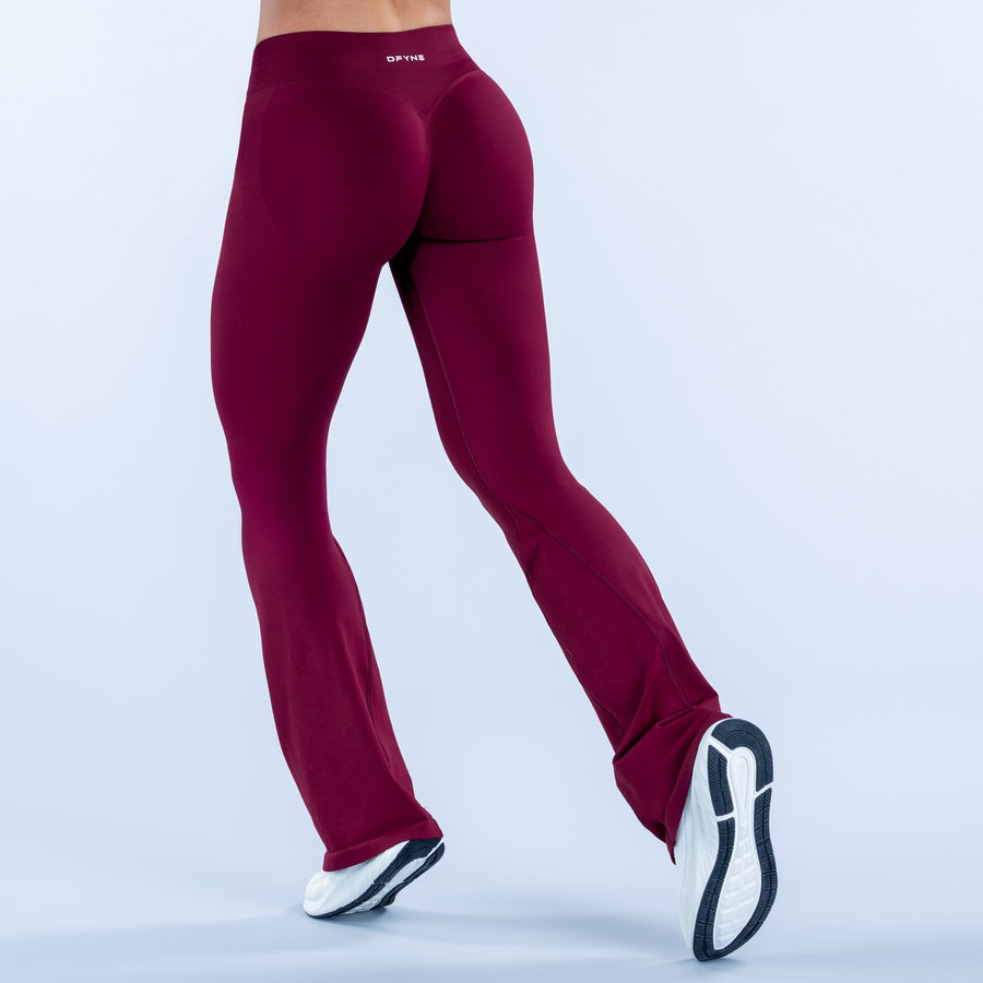 Burgundy flared leggings, side view with tapered knee-to-hem flare