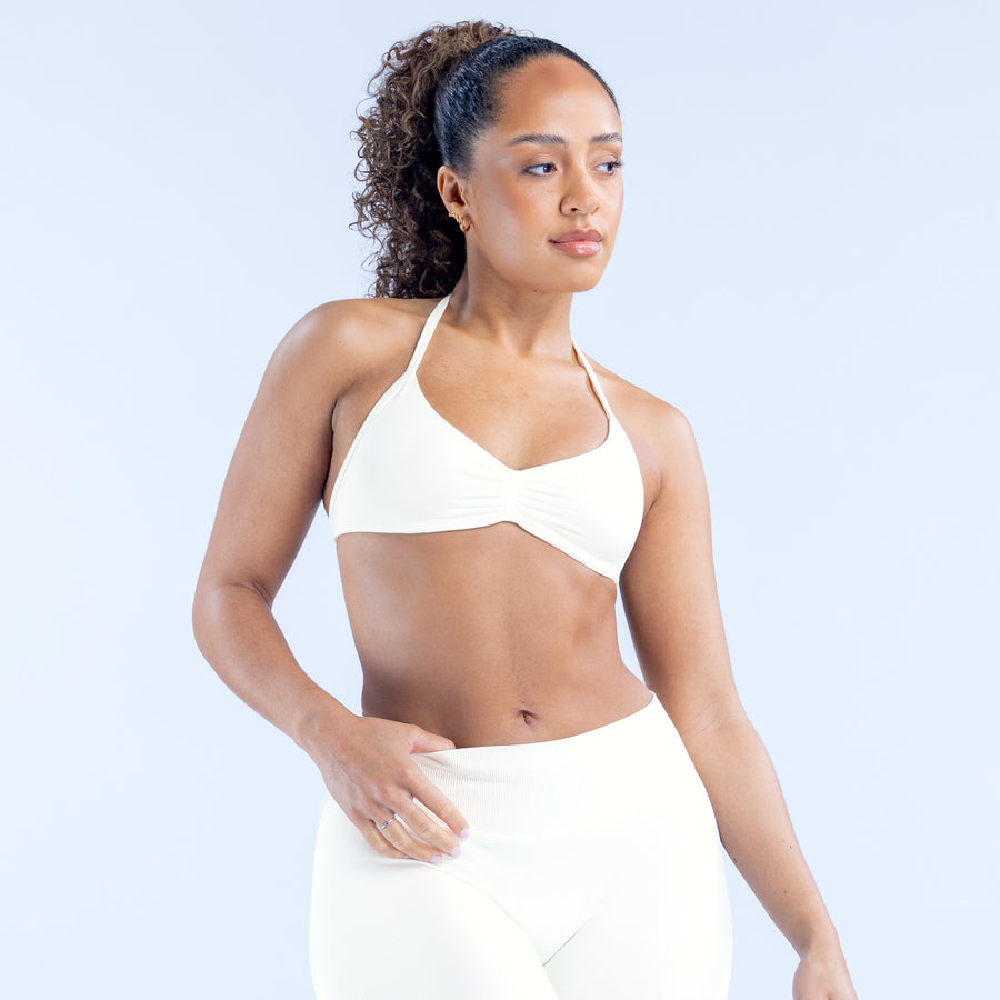 Impact strappy bra, white, triangle cups and thin straps, front view with hand