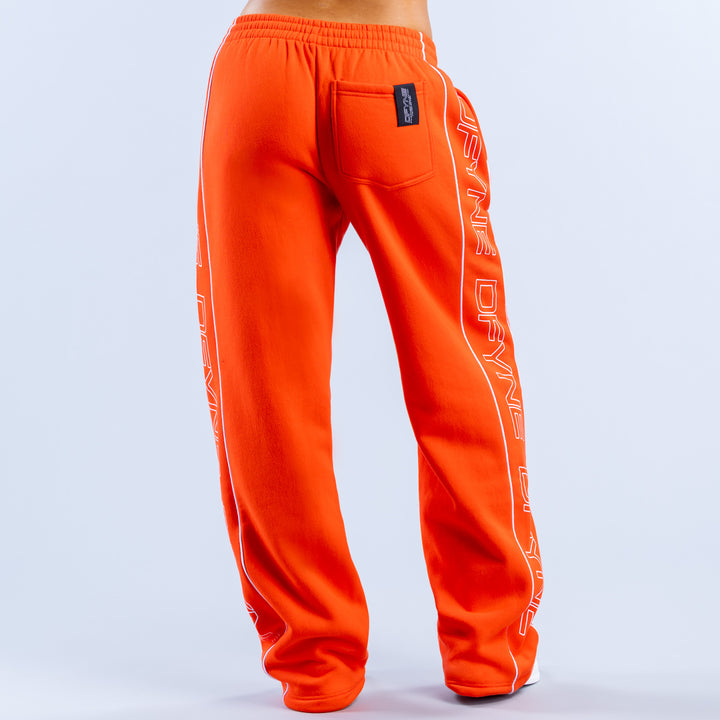 Orange wide-leg joggers with side stripe lettering and back patch pocket, elastic waist