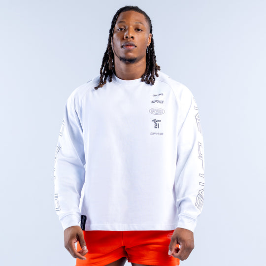 White long-sleeve kids top with small chest emblem and numbered graphic; orange shorts