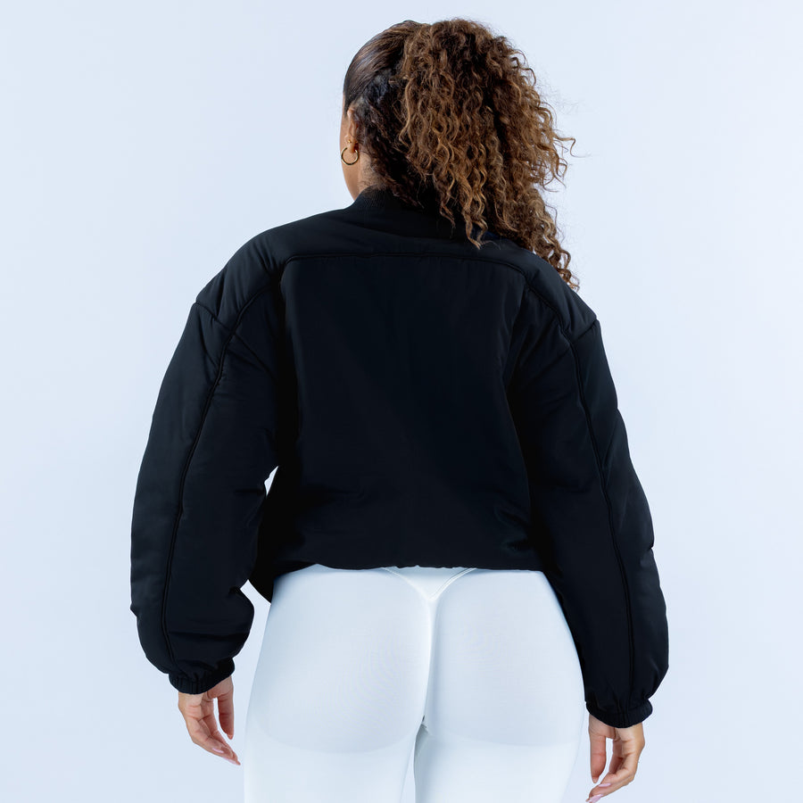 Black bomber jacket back view with ribbed cuffs and full sleeves
