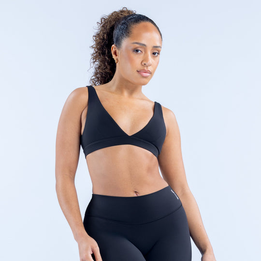 Black minimal sports bra with V-neck, wide straps, smooth molded cups