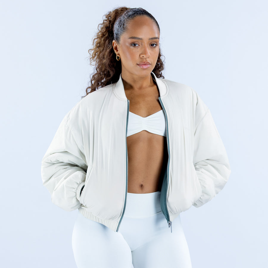 Reversible bomber jacket, white with zip-front, ribbed cuffs, and dark trim.