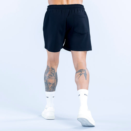 Dark athletic shorts with elastic waistband, relaxed fit shown from the back.