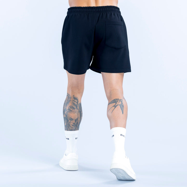 Dark athletic shorts with elastic waistband, relaxed fit shown from the back.