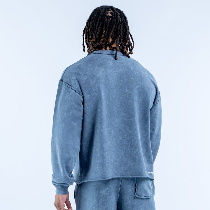 Washed blue crewneck sweatshirt, back view with ribbed cuffs and waistband