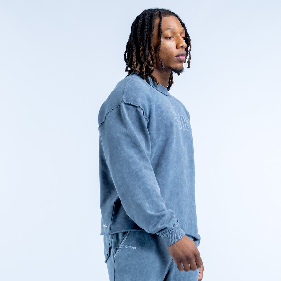 Washed blue crewneck sweatshirt, side view with sleeve graphic and kangaroo pocket