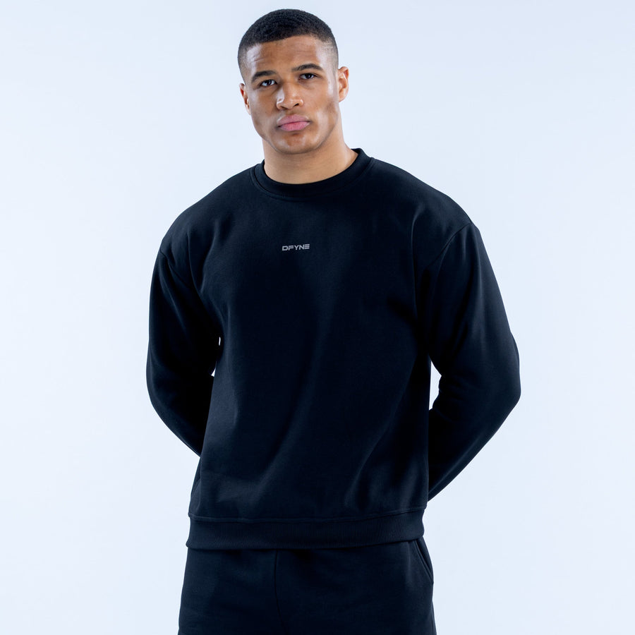 Black crewneck sweatshirt with small chest logo, ribbed cuffs and hem
