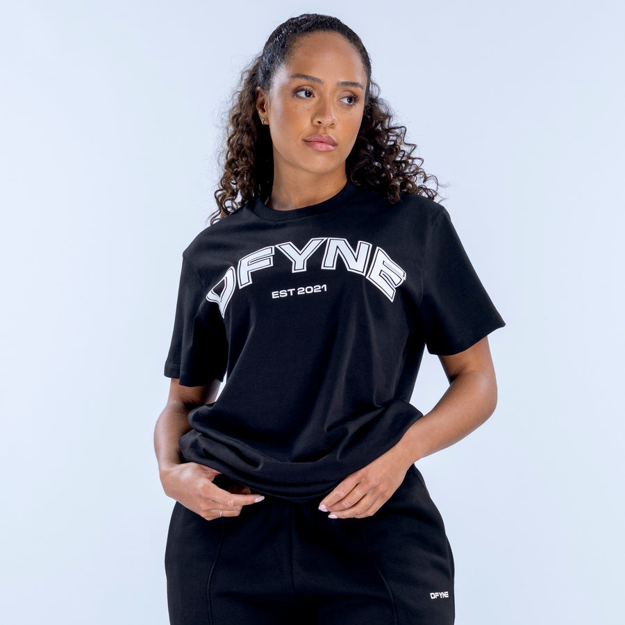 Black oversized tee with white “OFYN” logo and crew neck, worn with joggers