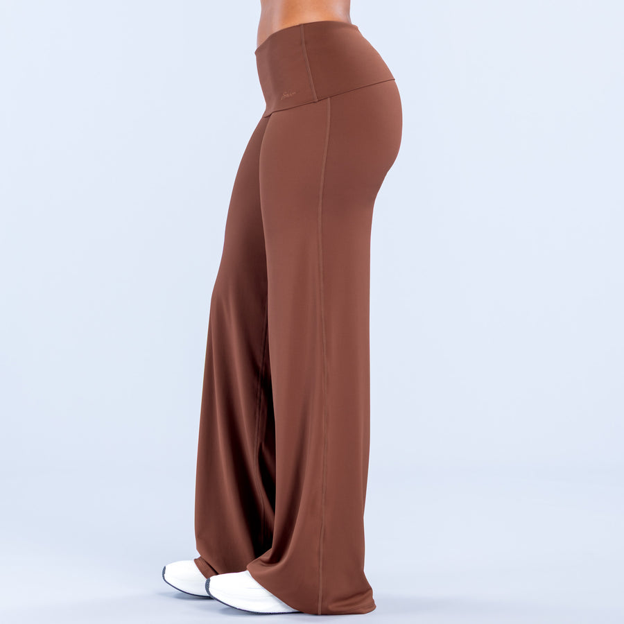 Fold-over wide-leg pants in rust brown, side view with draped leg opening