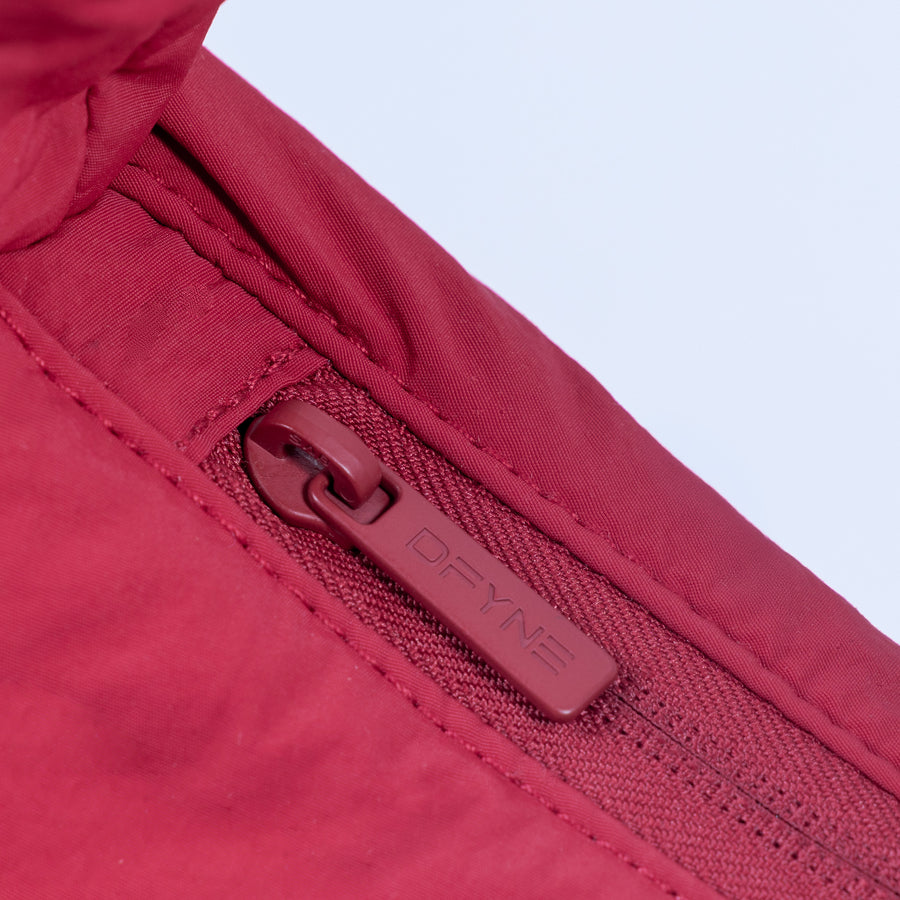 Red puffer bag zipper pull and fabric quilting detail