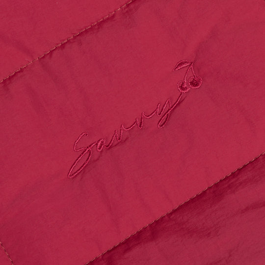Red Sav embroidered script logo on quilted fabric panel
