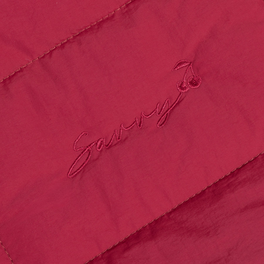 Red Sav embroidered script logo on quilted fabric panel
