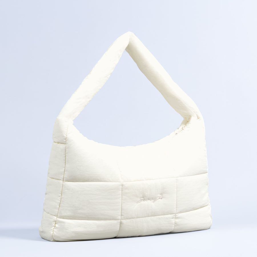 Sav puffer bag in off-white, quilted with top handle and rounded shoulder shape