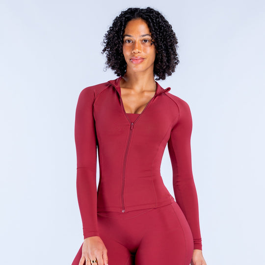 Women’s red zip-up hooded athletic top with long sleeves and front zipper
