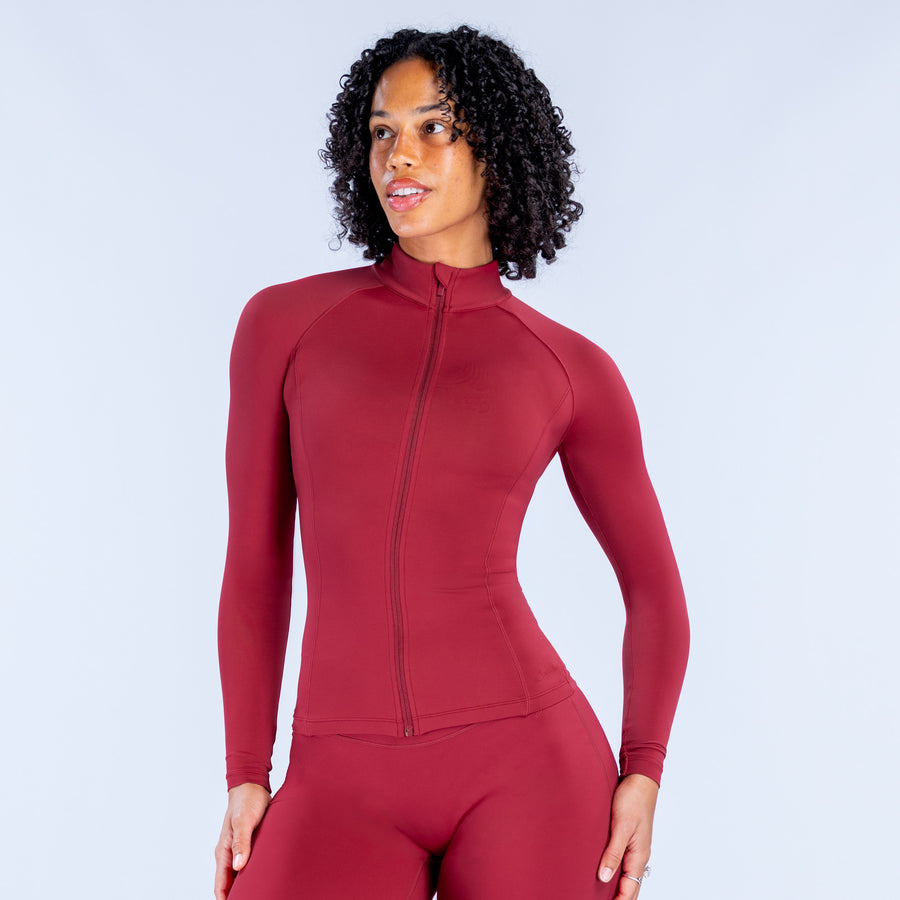 Burgundy women's zip-up performance top with stand collar and front zipper