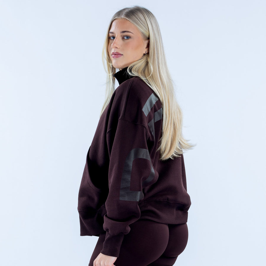 Dark plum quarter-zip sweatshirt with gray patch graphic on sleeve