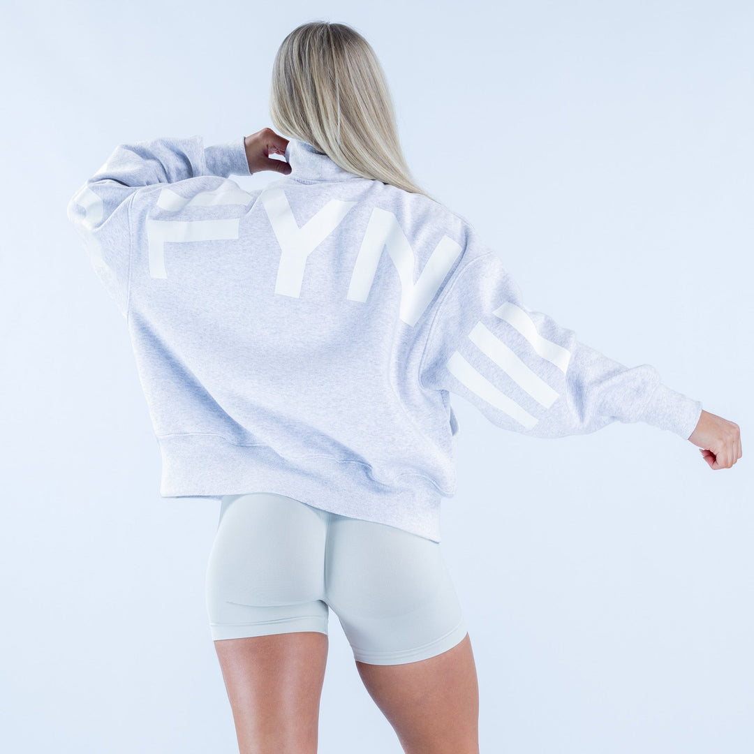 Light gray quarter-zip sweatshirt, back view with full sleeves and hem