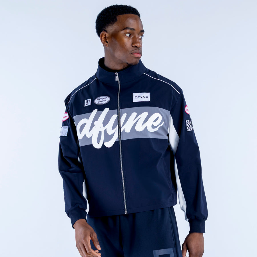 Two-tone track jacket with full zipper; navy base, large script chest print and patches