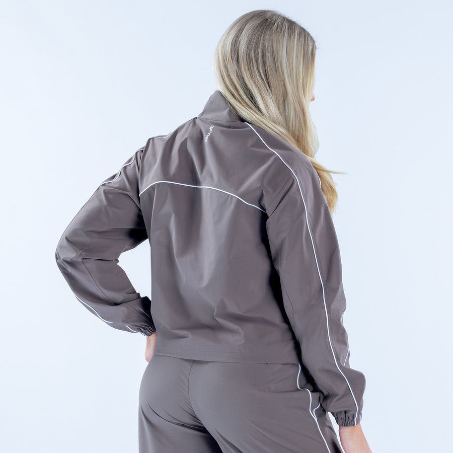Dark gray track jacket back view with white piping and elastic cuffs