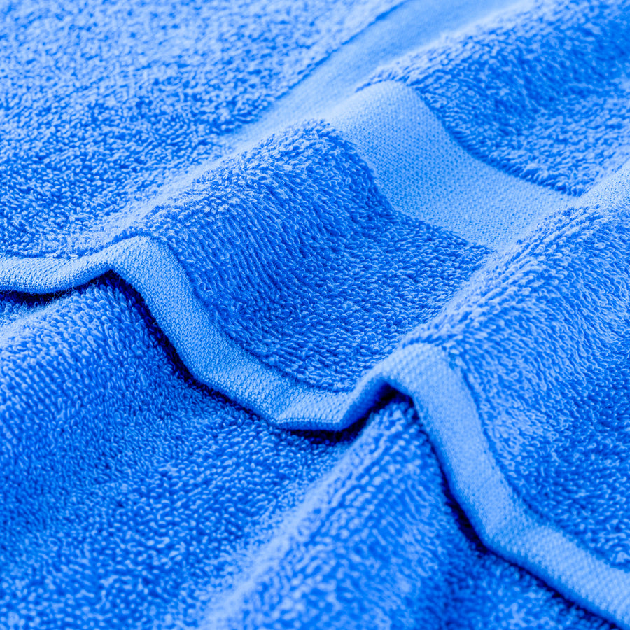 Blue gym towel fabric close-up with stitched edge and loop detail