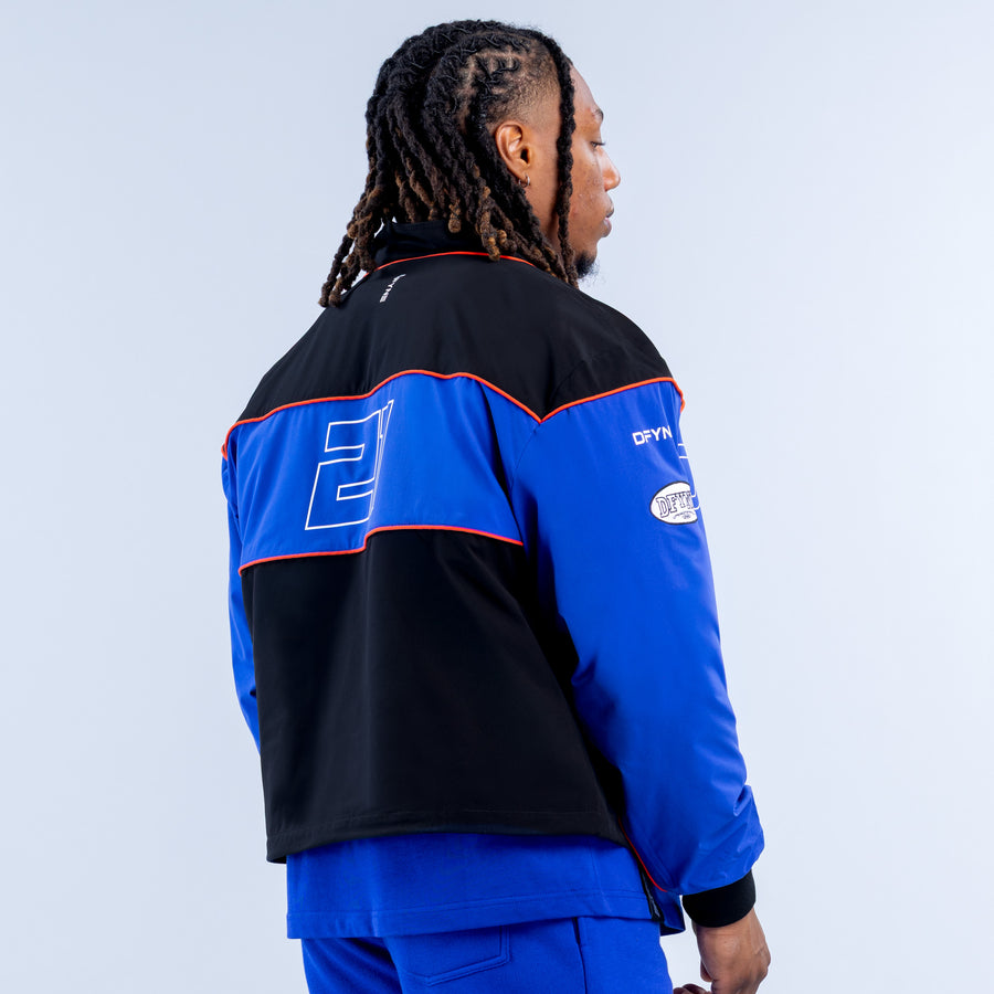 Kids track jacket back view, black and blue with red piping and logo panels