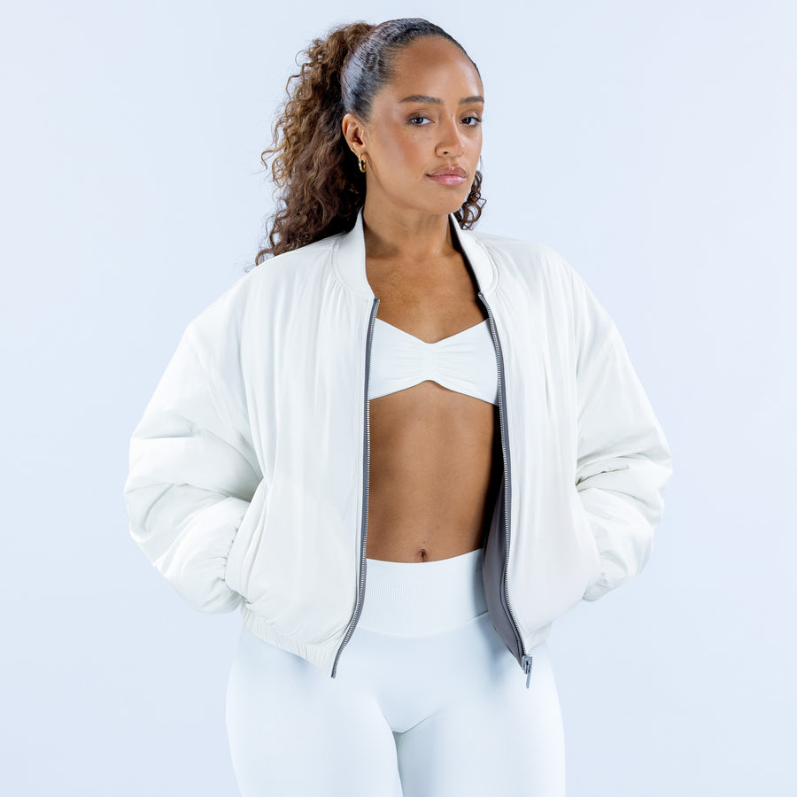 Reversible bomber jacket in white, front view with open zipper and ribbed cuffs