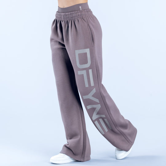 Taupe wide-leg joggers with elastic waist and diagonal 'DENY' logo print